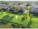 Aerial view of a home with a screened-in patio and a spacious backyard facing a pond at 5866 Cavano Dr, Sarasota, FL 34231