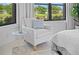 Relaxing reading nook in the bedroom with a striped chair and view of the pond at 5866 Cavano Dr, Sarasota, FL 34231