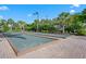 Outdoor bocce ball court lined with lush tropical landscaping and clear blue skies at 5866 Cavano Dr, Sarasota, FL 34231