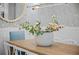 Close-up of a dining table with a white vase of flowers, surrounded by white chairs at 5866 Cavano Dr, Sarasota, FL 34231