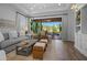 Open living room featuring a sliding glass door to the outdoor patio, hardwood flooring, and modern furniture at 5866 Cavano Dr, Sarasota, FL 34231