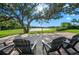 Comfortable patio seating with a view of the pond and lush green lawn under a shady tree at 5866 Cavano Dr, Sarasota, FL 34231