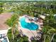Aerial view of a large community pool with seating surrounded by palm trees at 5866 Cavano Dr, Sarasota, FL 34231
