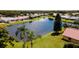 Aerial view of lush planned residential community with homes surrounding small lake at 5897 Carriage Dr, Sarasota, FL 34243