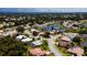 Aerial view of homes with lush landscaping and tile roofs in lake-centric residential community at 5897 Carriage Dr, Sarasota, FL 34243