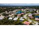 Aerial view of homes with mature trees and landscaping in residential community surrounding lakes at 5897 Carriage Dr, Sarasota, FL 34243