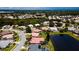Wide aerial view of neighborhood with ponds, mature trees and numerous tile roofs at 5897 Carriage Dr, Sarasota, FL 34243