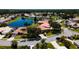 Aerial view of homes in residential community with tile roofs, landscaping, and lake at 5897 Carriage Dr, Sarasota, FL 34243