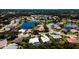Aerial view of houses within lush community built around a small lake and mature trees at 5897 Carriage Dr, Sarasota, FL 34243