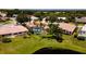 Eye-level aerial of properties with screened pools and lush landscaping near a pond at 5897 Carriage Dr, Sarasota, FL 34243