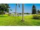 View of backyard green space sloping gently down to a small lake within a lovely residential community at 5897 Carriage Dr, Sarasota, FL 34243