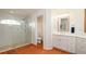 Well-lit bathroom featuring a walk-in shower with a glass door, a toilet, and a sink with white cabinets at 5897 Carriage Dr, Sarasota, FL 34243