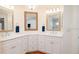 Bright bathroom with dual sinks, framed mirrors, and white cabinets, providing ample storage at 5897 Carriage Dr, Sarasota, FL 34243