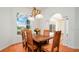 Bright dining room features a wooden table, view of the lake, and an elegant chandelier at 5897 Carriage Dr, Sarasota, FL 34243