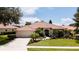 Aerial view features the home's lush lawn, driveway, terra cotta roof and landscaping at 5897 Carriage Dr, Sarasota, FL 34243