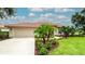 Exterior features terra cotta roof, a manicured lawn and tropical landscaping at 5897 Carriage Dr, Sarasota, FL 34243