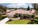 Aerial view of the home with terra cotta roof, pond view, and three-car garage at 5897 Carriage Dr, Sarasota, FL 34243