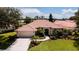 Aerial view of the exterior with terra cotta roof, large driveway and manicured lawn at 5897 Carriage Dr, Sarasota, FL 34243