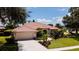 Attractive one-story home featuring a tile roof, a two-car garage, and professional landscaping at 5897 Carriage Dr, Sarasota, FL 34243