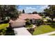 Aerial shot of the exterior featuring a terra cotta roof, palm trees, and landscaping at 5897 Carriage Dr, Sarasota, FL 34243