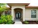 Inviting front entrance with double doors, arched transom window, and manicured landscaping at 5897 Carriage Dr, Sarasota, FL 34243