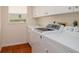 Convenient laundry room with a utility sink, washer, dryer, and tiled floor at 5897 Carriage Dr, Sarasota, FL 34243