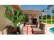 Enclosed patio featuring tiled flooring, a cushioned sofa, chairs, and tropical plants by the pool area at 5897 Carriage Dr, Sarasota, FL 34243