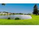 Tranquil view of a pond surrounded by lush green grass and neighboring homes at 5897 Carriage Dr, Sarasota, FL 34243
