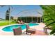 View of screened pool with lounge seating and tropical landscaping at 5897 Carriage Dr, Sarasota, FL 34243