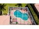 Aerial view of the in-ground kidney shaped screened-in pool with brick patio and outdoor seating at 5897 Carriage Dr, Sarasota, FL 34243