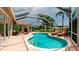 Sparkling screened-in pool area with lounge chairs and lush landscaping at 5897 Carriage Dr, Sarasota, FL 34243