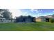 Backyard with screened-in pool, grass, and view of neighboring houses at 6107 French Creek Ct, Ellenton, FL 34222