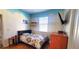 A bedroom featuring a bed with a floral comforter, a dresser and a mounted television at 6107 French Creek Ct, Ellenton, FL 34222