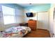 Bright bedroom featuring hardwood floors, closet, a dresser, and a TV at 6107 French Creek Ct, Ellenton, FL 34222