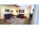 Living room showcases a floral rug, purple couches, and neutral walls with barn-themed artwork at 6107 French Creek Ct, Ellenton, FL 34222
