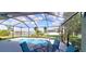 Enclosed pool area with a lake view, showcasing outdoor seating and a serene backyard oasis at 6107 French Creek Ct, Ellenton, FL 34222