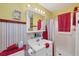 Bright and clean bathroom features a single sink vanity, a shower with curtain, and red striped wallpaper at 619 Albee Farm N Rd, Nokomis, FL 34275