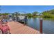 Lakeside dock featuring a boat lift with bench seating offering a relaxing waterfront experience at 619 Albee Farm N Rd, Nokomis, FL 34275