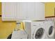 Bright laundry room with washer, dryer, sink, and upper cabinets for storage at 619 Albee Farm N Rd, Nokomis, FL 34275