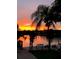 Beautiful waterfront view with palm trees, sunset colors, and seating on the property at 619 Albee Farm N Rd, Nokomis, FL 34275