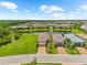 Aerial view of homes with tile roofs, well manicured lawns and a scenic pond in the community at 6791 Alstead Cir, Bradenton, FL 34202