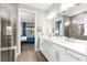 Stylish bathroom featuring double sinks, a glass-enclosed shower, and a glimpse of the bedroom at 6791 Alstead Cir, Bradenton, FL 34202