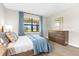 Serene bedroom with wood floors, a cozy bed, and bright natural light from a large window at 6791 Alstead Cir, Bradenton, FL 34202