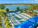 Aerial view of Bocce ball courts with blue canopies, surrounded by a beautiful lake and landscape at 6791 Alstead Cir, Bradenton, FL 34202