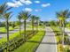Scenic view of a tree-lined road leading to the community entrance with lush landscaping under a clear blue sky at 6791 Alstead Cir, Bradenton, FL 34202