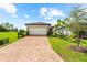 Charming home with a brick driveway and lush landscaping under a bright blue sky at 6791 Alstead Cir, Bradenton, FL 34202