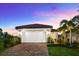Charming home with a two-car garage and lush landscaping under a beautiful dusk sky at 6791 Alstead Cir, Bradenton, FL 34202