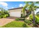 Charming home with a brick driveway, lush landscaping, and a manicured lawn under a bright sky at 6791 Alstead Cir, Bradenton, FL 34202