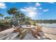 Outdoor lakeside firepit surrounded by Adirondack chairs and lush landscaping, perfect for evening gatherings at 6791 Alstead Cir, Bradenton, FL 34202
