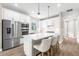 Bright kitchen featuring stainless steel appliances, white cabinets, and an island with three chairs at 6791 Alstead Cir, Bradenton, FL 34202